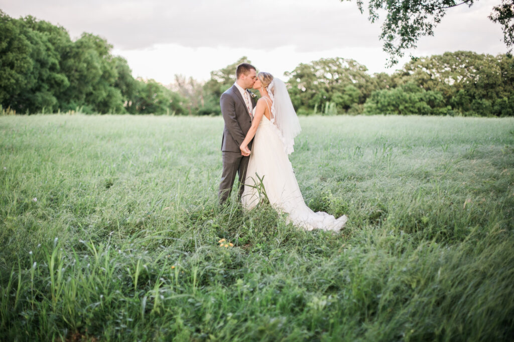 wedding couple kissing in field